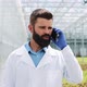 Worker Walking in a Greenhouse Using Mobile and Talking on Smartphone - VideoHive Item for Sale
