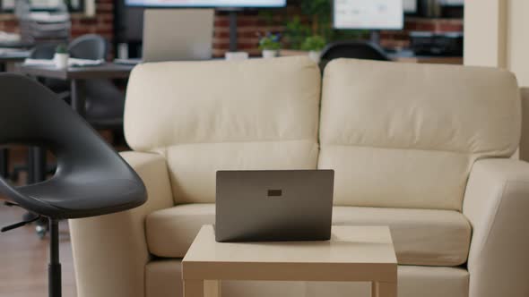 Empty Startup Office with Couch and Laptop Computer