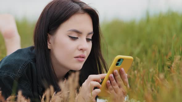 Caucasian Pretty Girl Serene Woman Lying on Grass Enjoy Free Time Alone Outdoors Use Smartphone