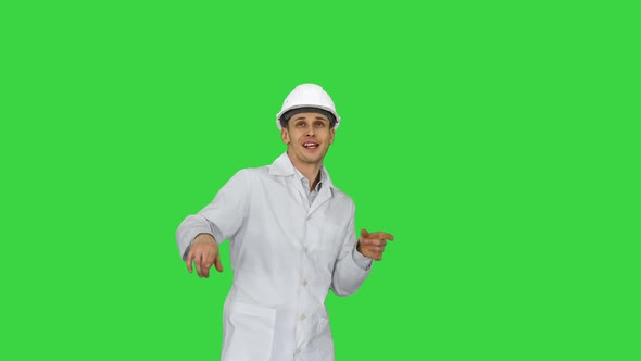 Funny Scientinst in White Robe and Safety Helmet Dancing on a Green Screen, Chroma Key