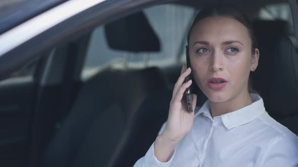 Thoughtful Busy Young Businesswoman Talking on Phone Sitting on Driver's Seat in Car