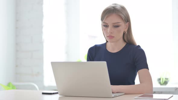 Woman Leaving Office After Closing Laptop