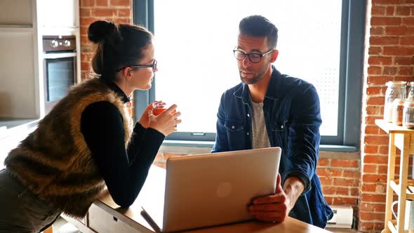 Couple interacting with eachother while using laptop while