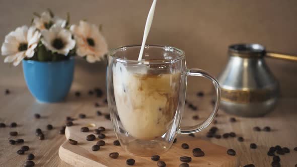 Slow motionMilk Cream is Poured Into a Iced Coffee