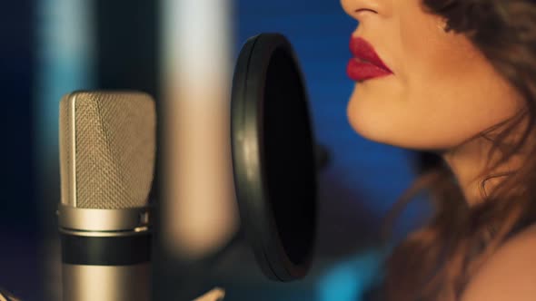 Woman singing in a recording studio. Female vocals. Professional recording studio.