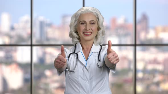Cheerful Female Doctor Gesturing Two Thumbs Up