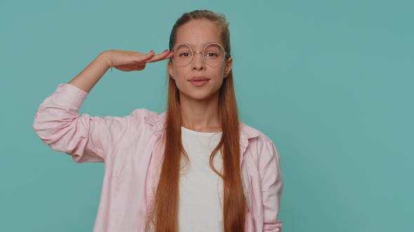 Serious Teenager Girl Giving Salute Listening to Order As If Soldier Following Discipline Obeying