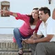 Young couple sitting on steps with guidebook - VideoHive Item for Sale
