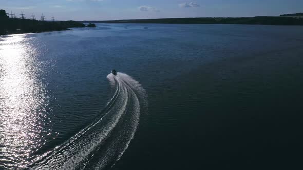 Boat with people floating on river. Aerial drone shot of sailing motor ship in the middle of river