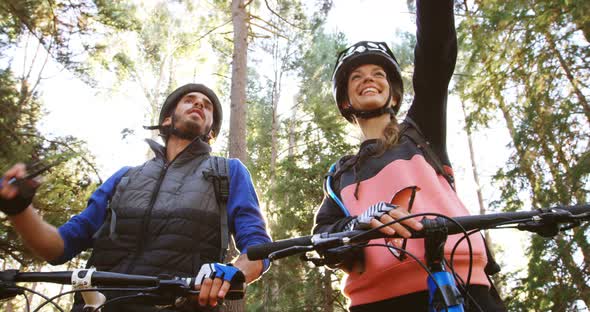 Mountain biking couple pointing at nature