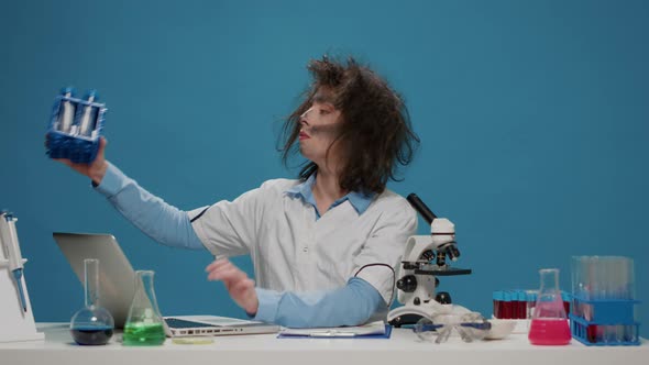 Funny Insane Female Scientist Looking at Test Tubes on Desk