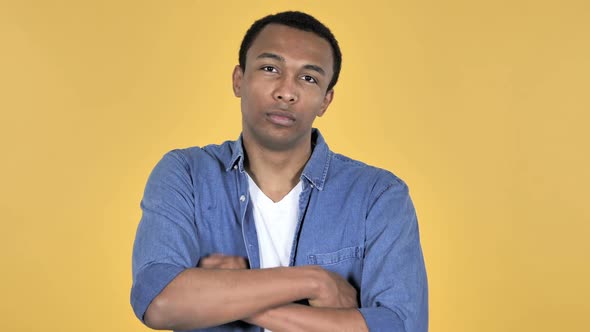 Young African Man Looking at Camera Yellow Background