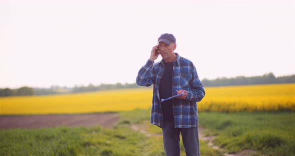 Farmer Talking on Mobile Phone While Working in a Field Agriculture