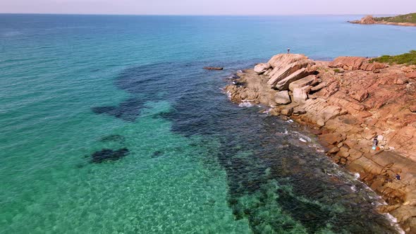 Drone flyby of fisherman fishing off rocks in castle rock in Dunsborough Western Australia