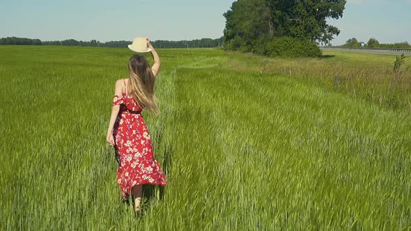 Slow Motion Young Girl Runs Across Green Field in Red Dress That Flutters in the Wind She Takes Off
