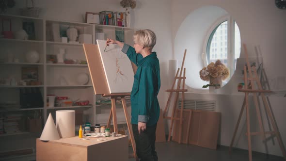 A Young Woman Artist Painting Tree in Green Color in the Art Studio