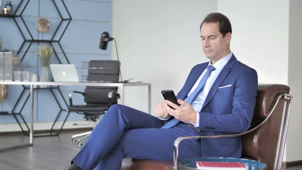 Happy Businessman Excited for Success, Using Smartphone