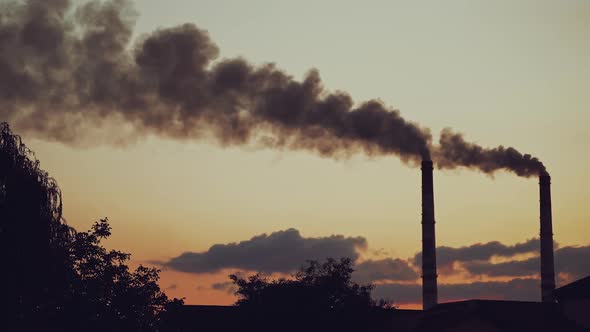 Industrial pipes with thick smoke pollute the atmosphere