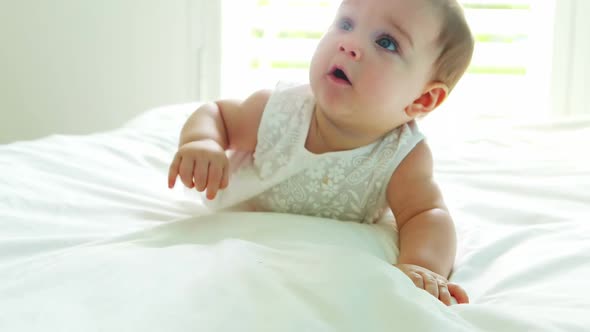 Cute baby girl playing on bed