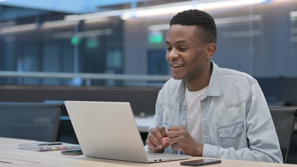 Successful African Man Celebrating on Laptop at Work