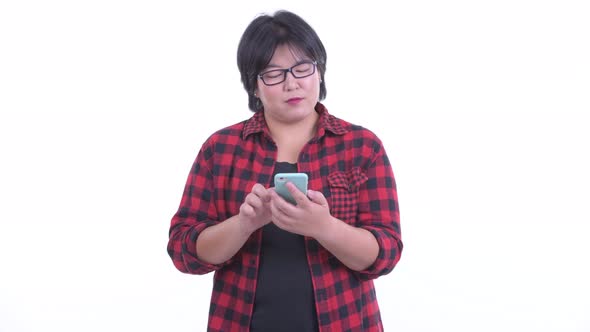 Happy Overweight Asian Hipster Woman Thinking While Using Phone