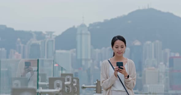 Woman look at mobile phone in Hong Kong city