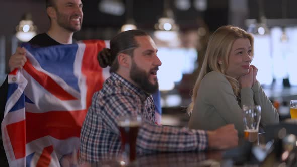 Sport Fans with British Flag Watching Match in Pub Supporting National Team