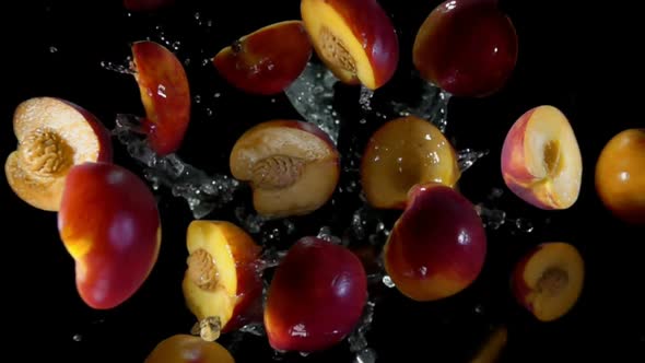 Halves of a Peach Fly Up in Splashes of Water