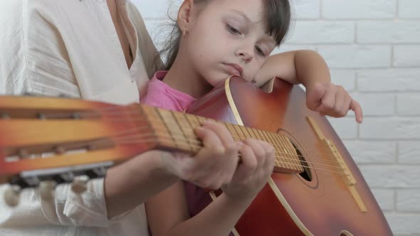 Play the guitar with mother. 