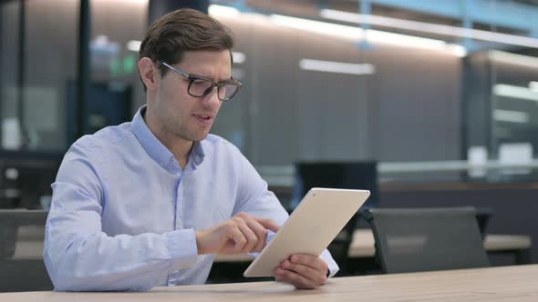 Young Man Having Loss on Tablet at Work