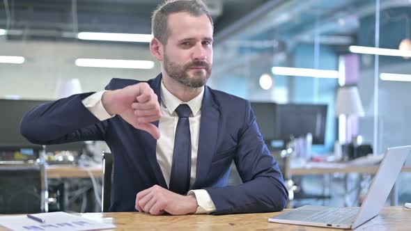 Disappointed Young Businessman Showing Thumbs Down