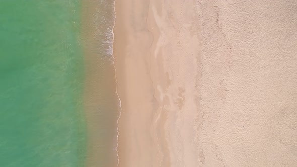 Aerial view top down Sea waves crashing on beach Phuket Thailand