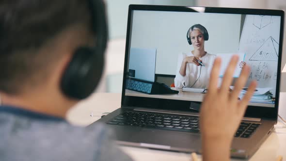 Schoolboy Waving at a Teacher While Attending an Online Class