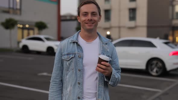 Smiling Man Holding Takeaway Coffee in City