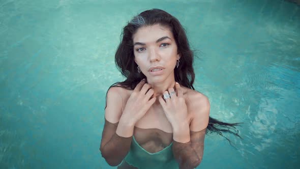 Young Glamour Woman in Bikini Standing at the Edge of the Pool on Villa and Looking at the Camera