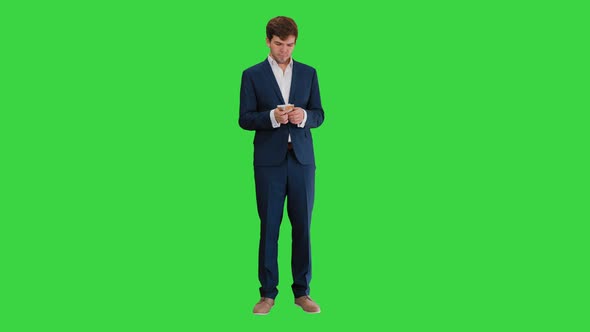 Happy Businessman Counting Money and Tucking It Inside a Jacket Pocket on a Green Screen, Chroma Key