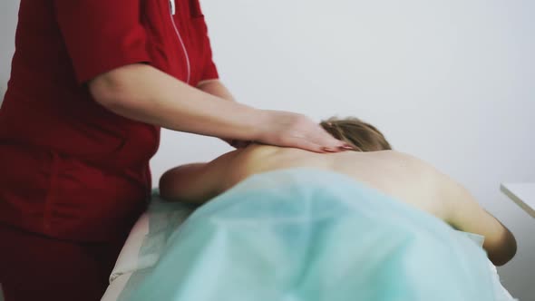 Massage Therapist Does Classical Procedure with Patient Back