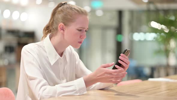 Disappointed Young Businesswoman Having Loss on Smartphone