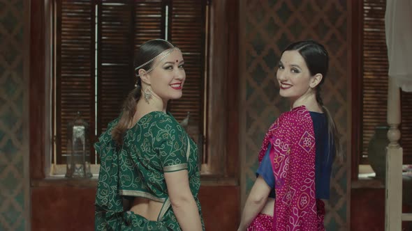 Smiling Women in Saree Looking Back Over Shoulders