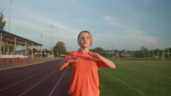 Young Beautiful Girl in Sweatpants and an Orange Tshirt Goes in for Sports