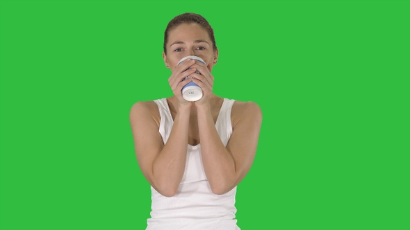 Relaxed woman drinking coffee on a Green Screen, Chroma Key.