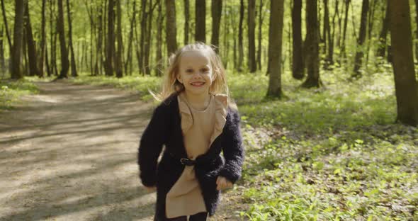 Little Happy Girl Runs Through The Woods
