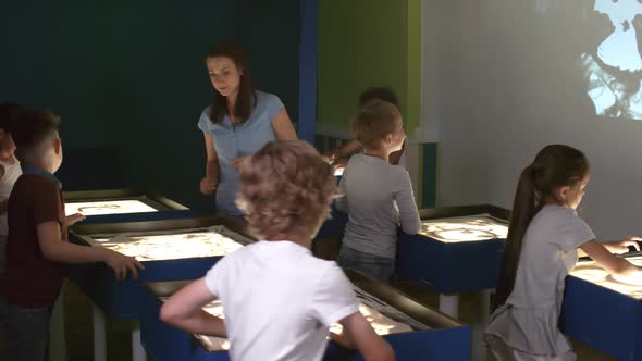 Teacher Helping Kids in Sand Animation Class