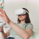 Young woman in VR experience while sitting wearing goggles and controller - VideoHive Item for Sale