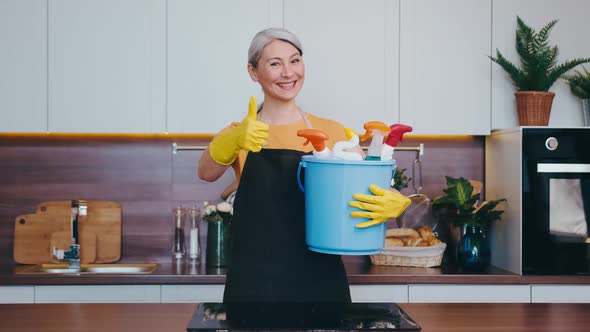 Asian Looking Woman Shows Thumb Up with Her Cleaning Bucket