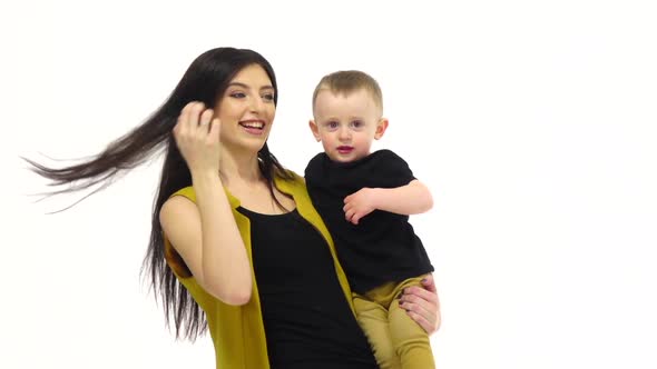 Girl Is Holding Her Child in Her Arms, White Background, Slow Motion