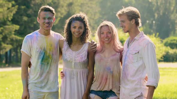 Young Friends Covered in Holi Colors, Happy People Hugging and Smiling to Camera