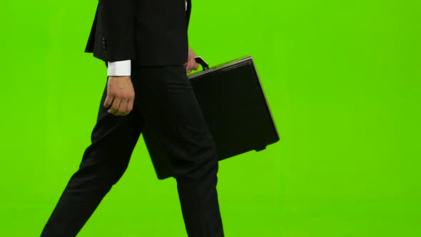 Man Holds a Briefcase in His Hand, He Rushes Over It. Green Screen