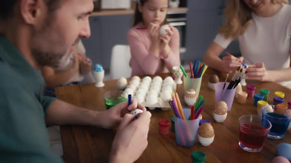 Caucasian family of four people decorating easter eggs at home. Shot with RED helium camera in 8K
