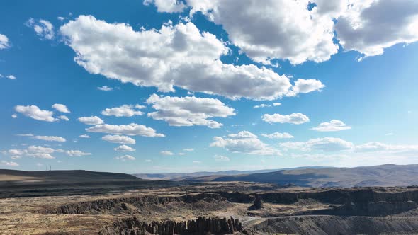 Wide aerial shot over Frenchman Coulee featuring the beautiful clouds floating over top in the sky.